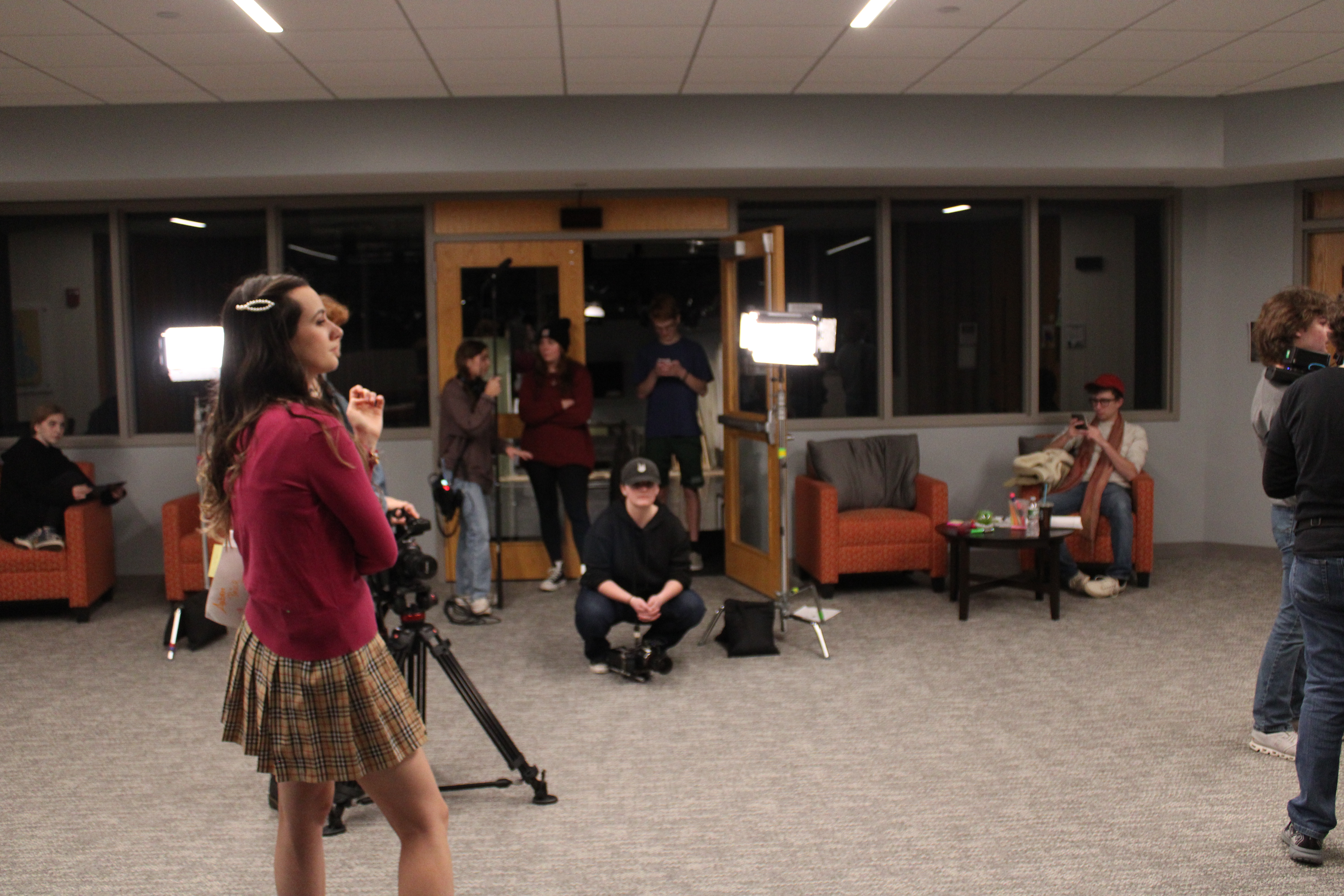 The camera crew watches an actress perform a scene.