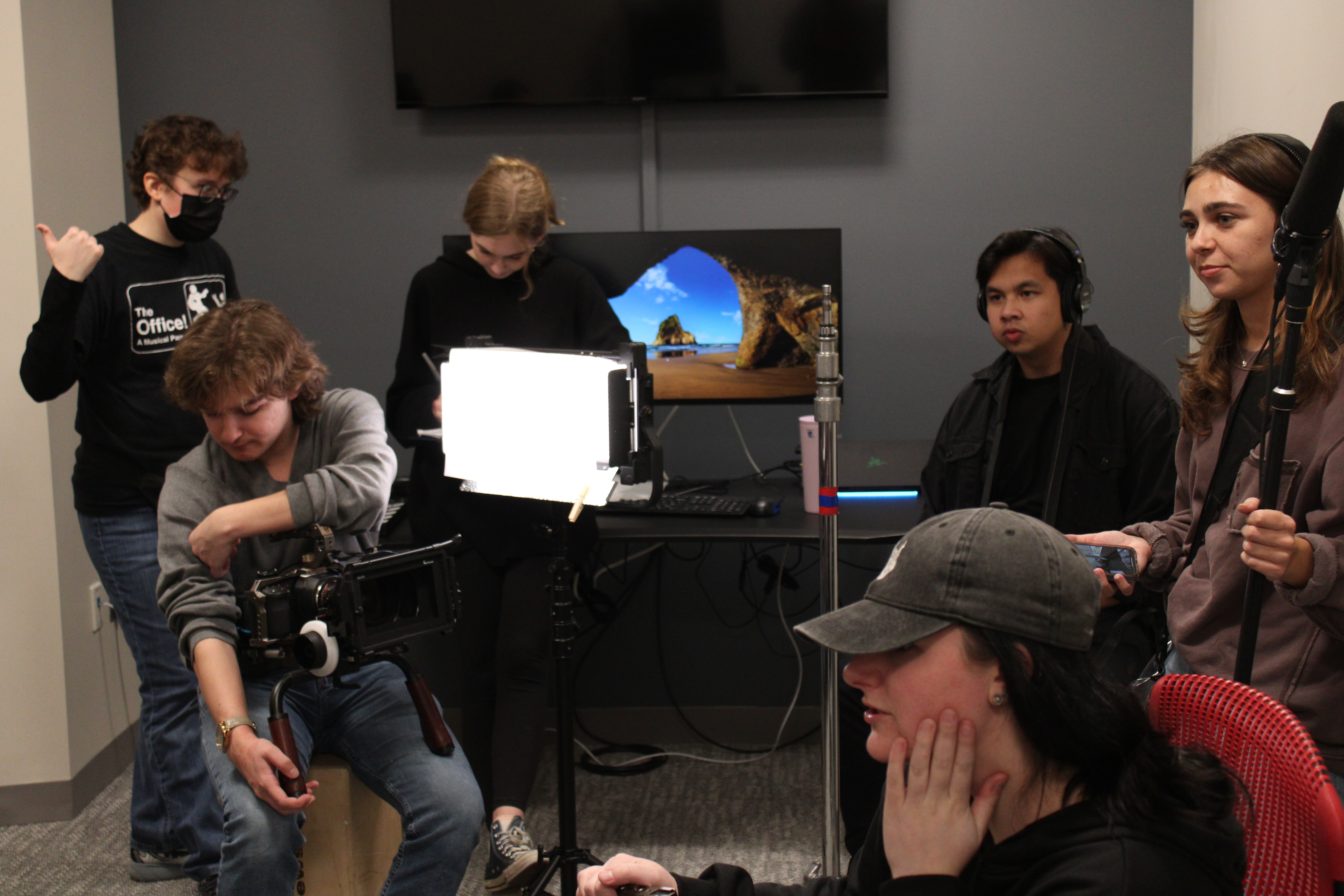 The film crew prepares the lights, camera, and sound for a confessional.