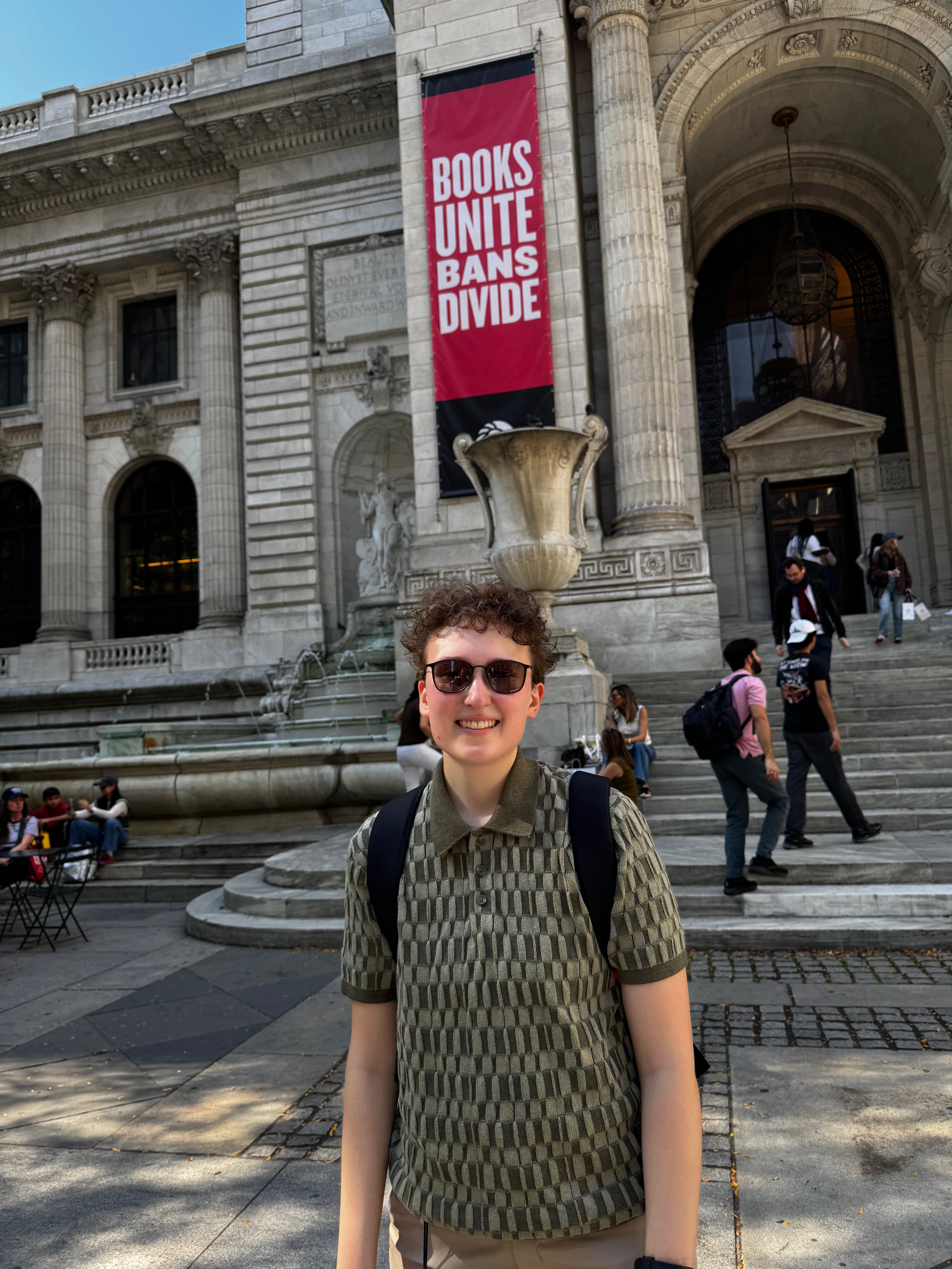 Taylor with a banner that says "Books Unite. Bans Divide."